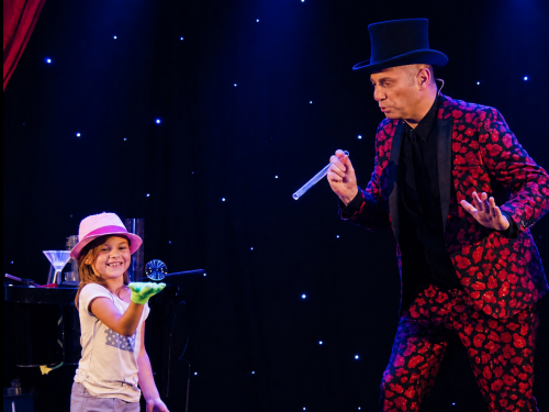 Allan Hart fait participer deux enfants lors d'une séance de jonglage de bulles dans son spectacle